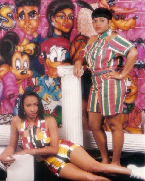 Early 90s esque photo of two women posing with a grafitti background